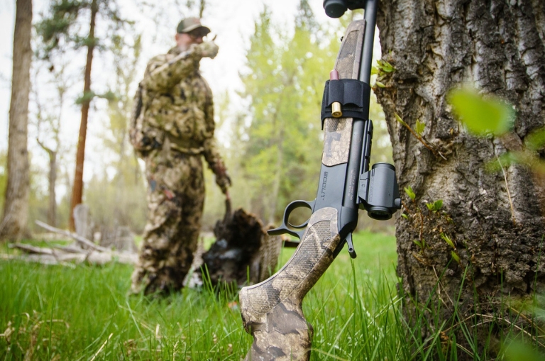 Rifle CVA Scout monotiro apoyado en un árbol durante una jornada de caza