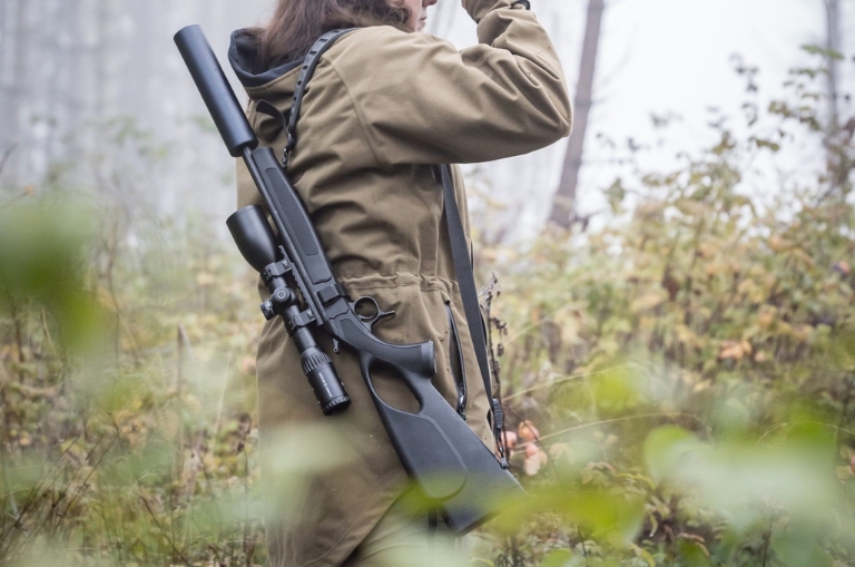 Rifle CVA Scout TD takedown colgado al hombro durante una salida al campo