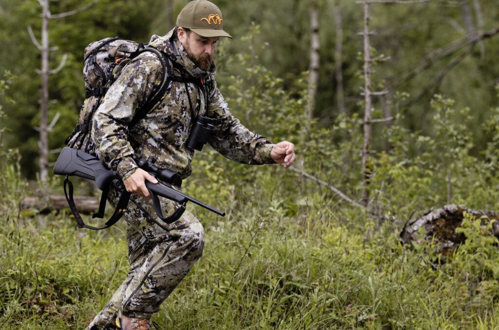 Cazador en rececho con rifle Blaser R8 Professional 2.0 en entorno de monte